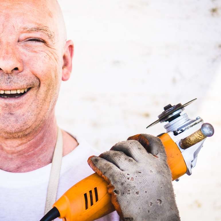 man holding orange angle grinder online puzzle