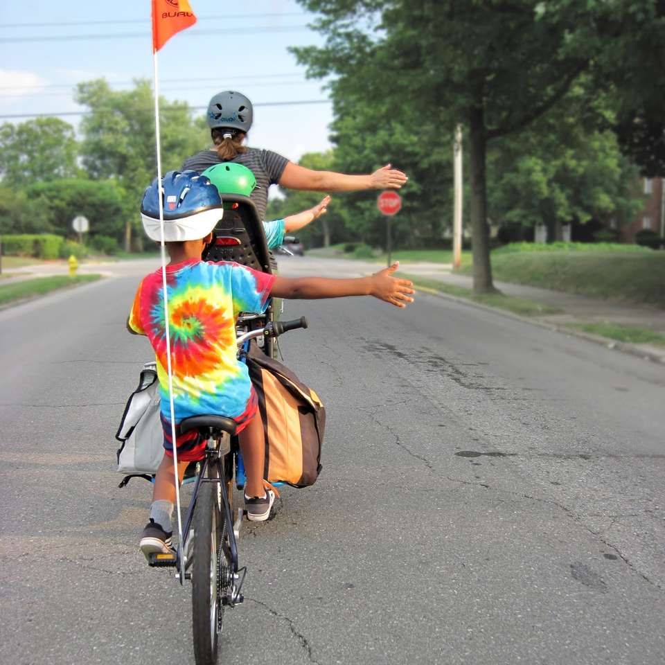жена в синя и червена рокля, караща велосипед по пътя онлайн пъзел