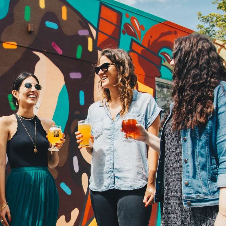 fyra kvinnor som håller drinkar medan de skrattar tillsammans Pussel online