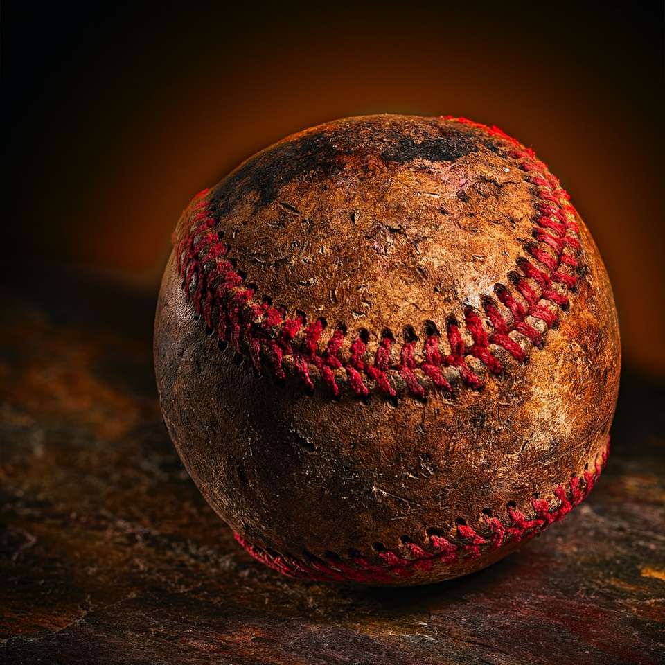 коричневий бейсбольний м'яч на коричневій поверхні онлайн пазл