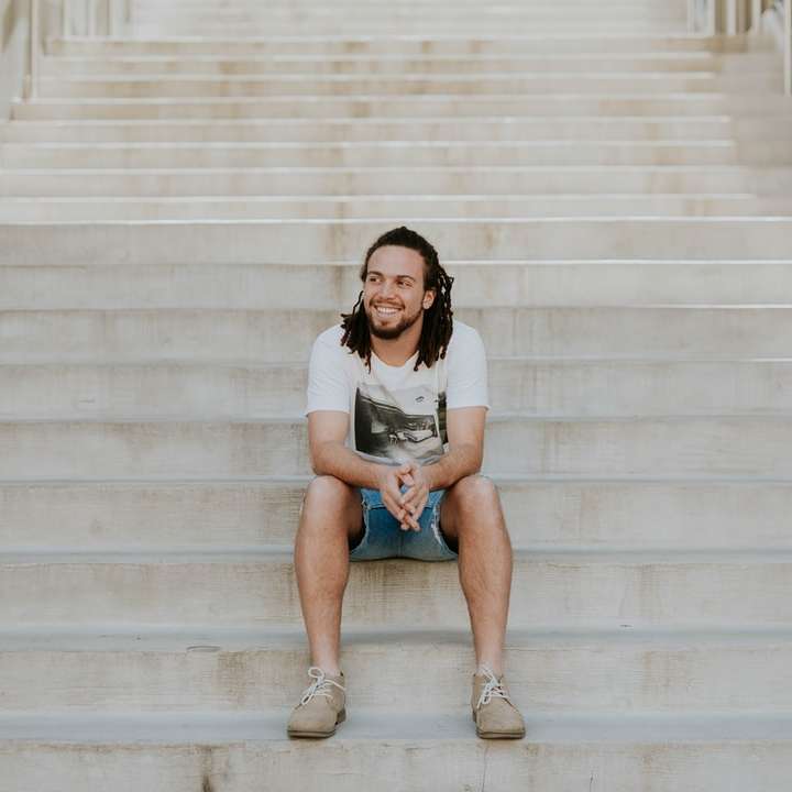homem sorridente sentado na escada puzzle deslizante online