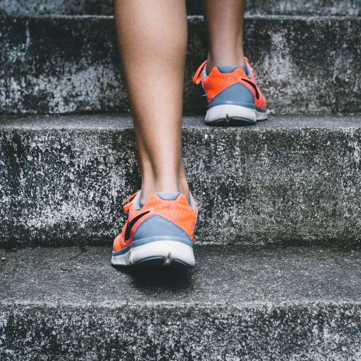 narancssárga és szürke Nike cipőt viselő személy online puzzle