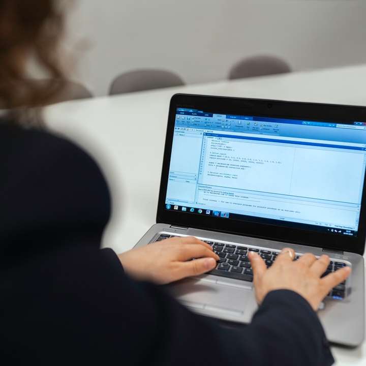 Frau im schwarzen Langarmhemd mit MacBook Pro Online-Puzzle
