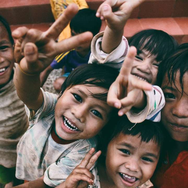 vijf kinderen glimlachen terwijl het doen van vrede handteken schuifpuzzel online