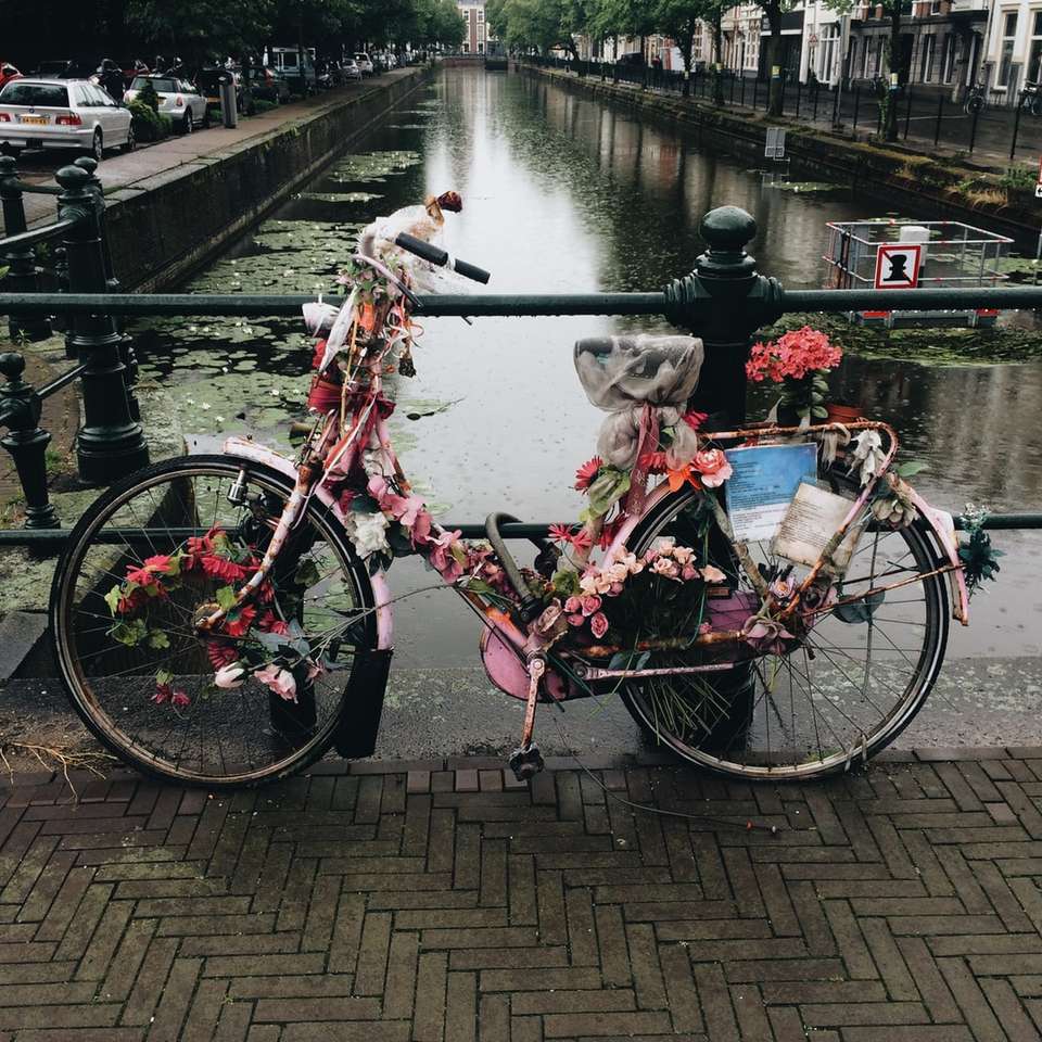 ποδήλατο καλυμμένο με λουλούδια στη γέφυρα κοντά σε λίμνη συρόμενο παζλ online