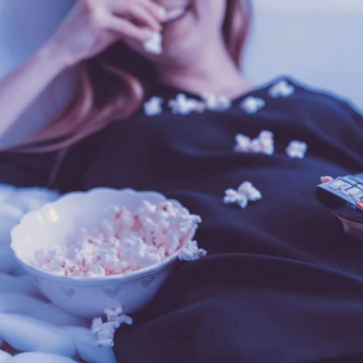 vrouw liggend op bed tijdens het eten van bladerdeeg maïs schuifpuzzel online