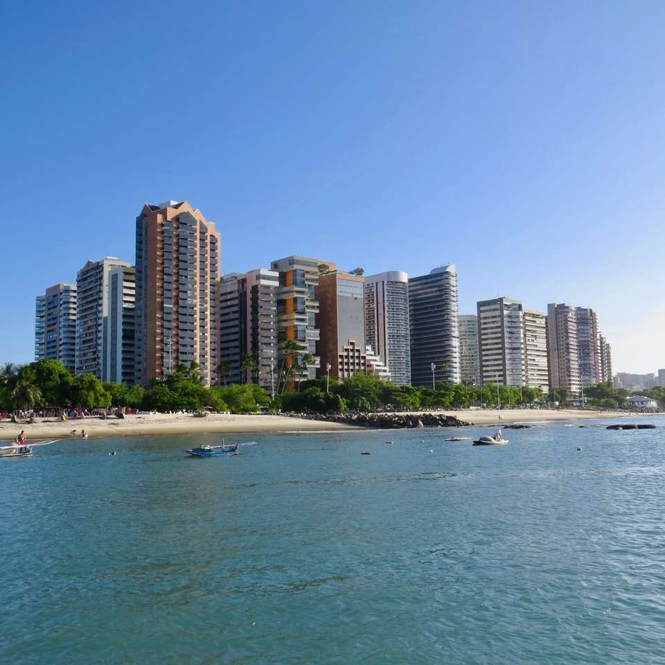 városi épületek a tenger közelében, kék ég alatt nappali online puzzle