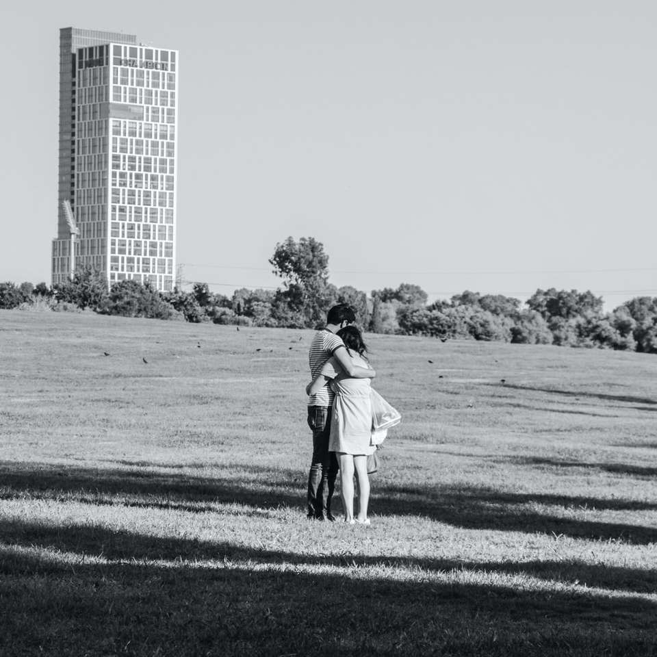 photo en niveaux de gris de l'homme et de la femme marchant sur le terrain en herbe puzzle coulissant en ligne