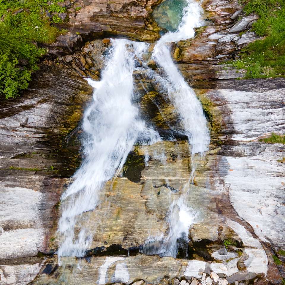 водата пада върху кафява скалиста планина плъзгащ се пъзел онлайн