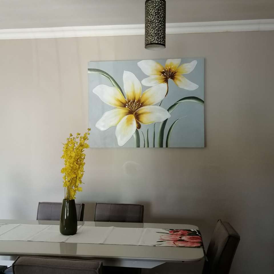 biały i żółty kwiat w czarnym wazonie na białym stole puzzle przesuwne online