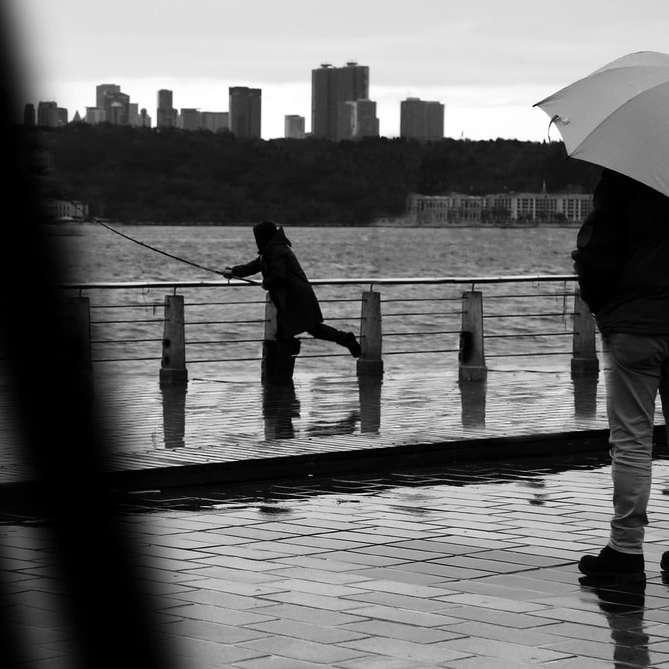 снимка в сивата скала на мъж и жена, държащи чадър онлайн пъзел