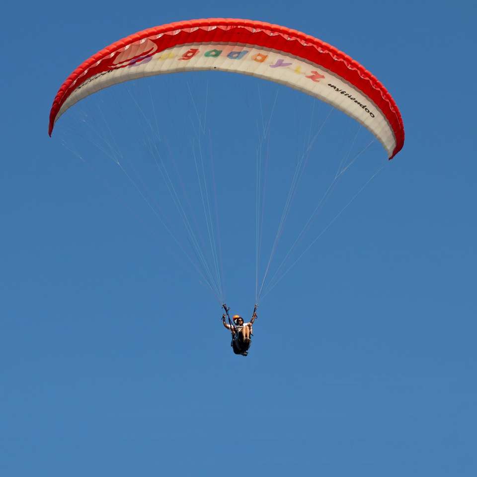 Persona en paracaídas amarillo en el aire durante el día. puzzle deslizante online