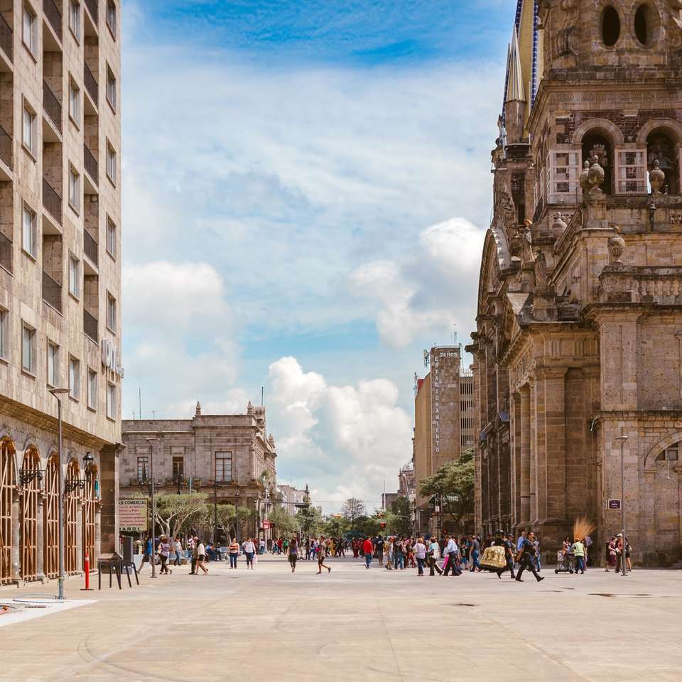 persone che camminano vicino alla cattedrale antica marrone puzzle scorrevole online