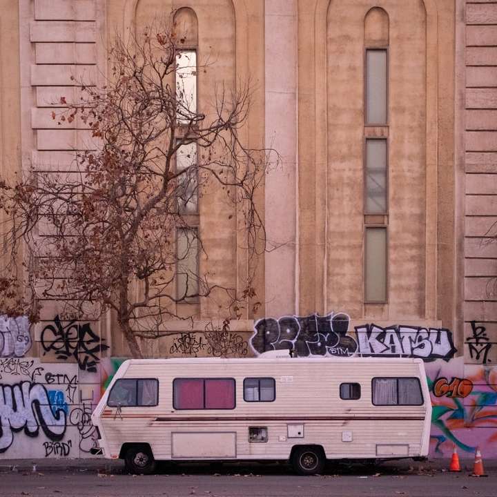 білий фургон, припаркований біля коричневої будівлі розсувний пазл онлайн