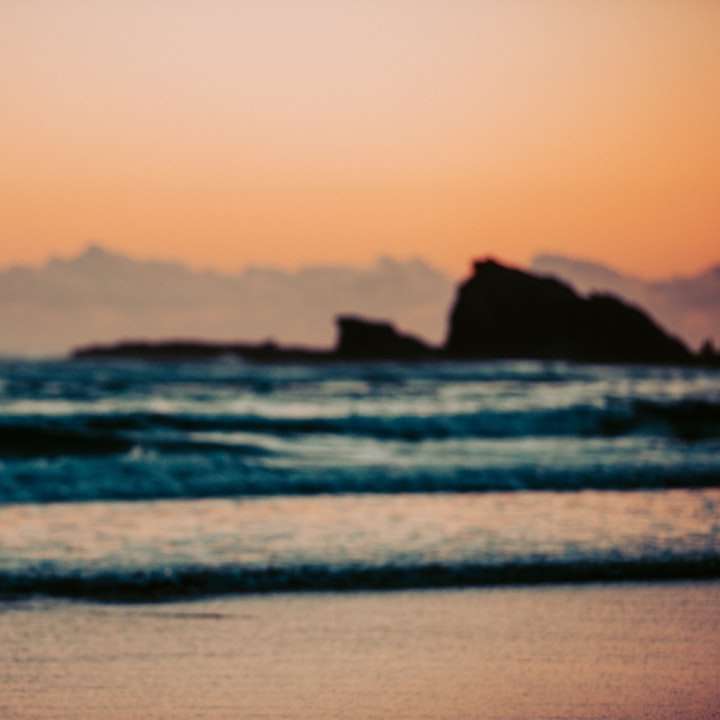 fehér és barna strand sátor a tengerparton naplemente alatt online puzzle