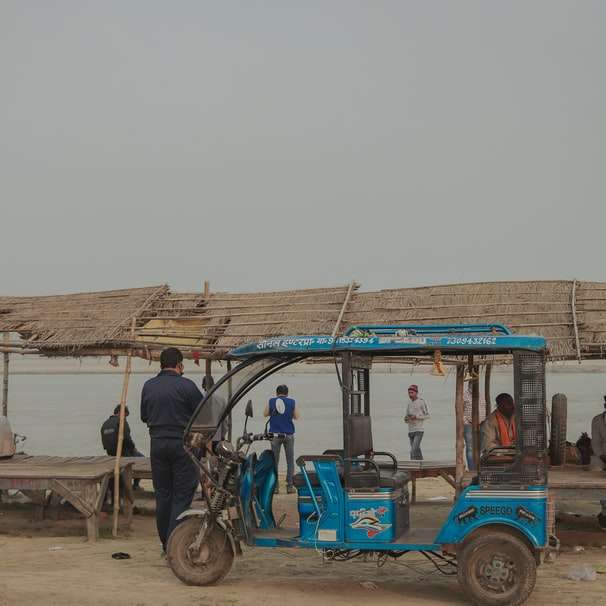 μπλε και μαύρο auto rickshaw σε καφέ ξύλινη αποβάθρα συρόμενο παζλ online