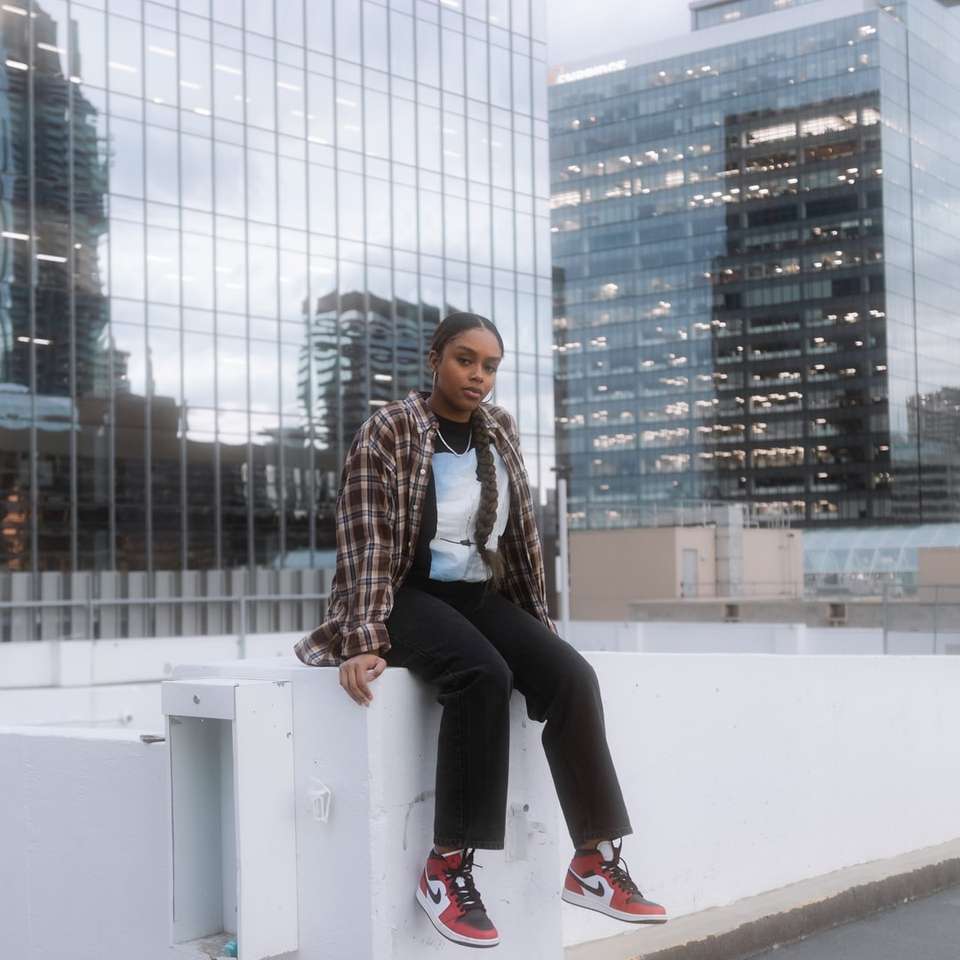 woman in black pants sitting on white concrete bench online puzzle