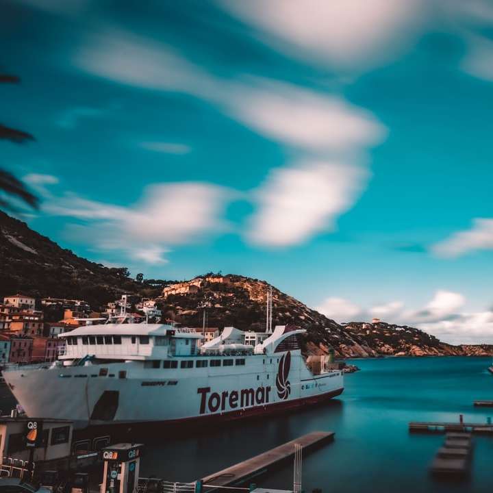 Barco blanco y azul en el muelle marítimo bajo un cielo azul puzzle deslizante online