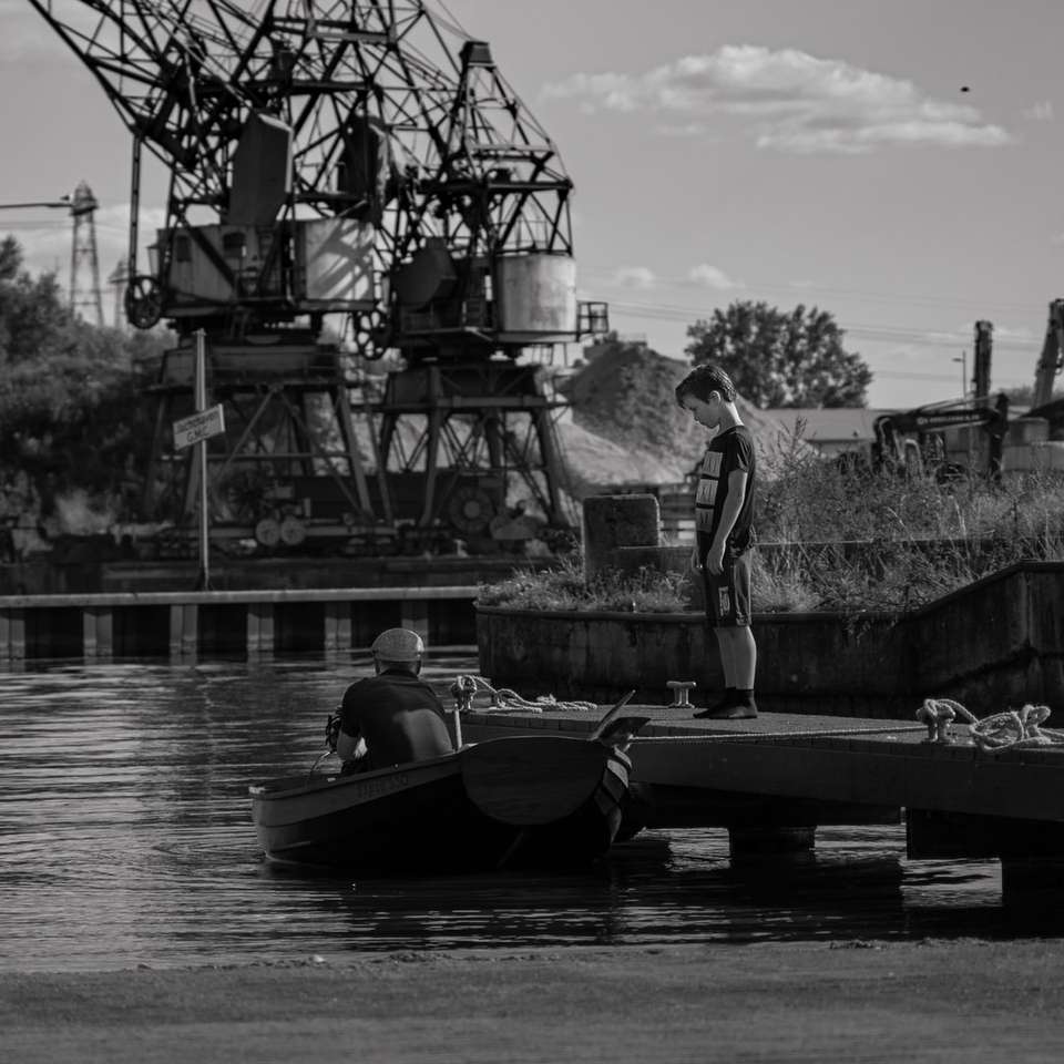 grayscale photo of man riding on boat online puzzle
