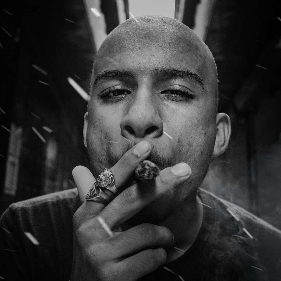 homem fumando cigarro em fotografia em tons de cinza puzzle online