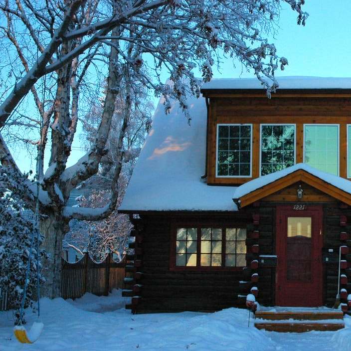 καφέ ξύλινο σπίτι καλυμμένο με χιόνι κατά τη διάρκεια της ημέρας συρόμενο παζλ online