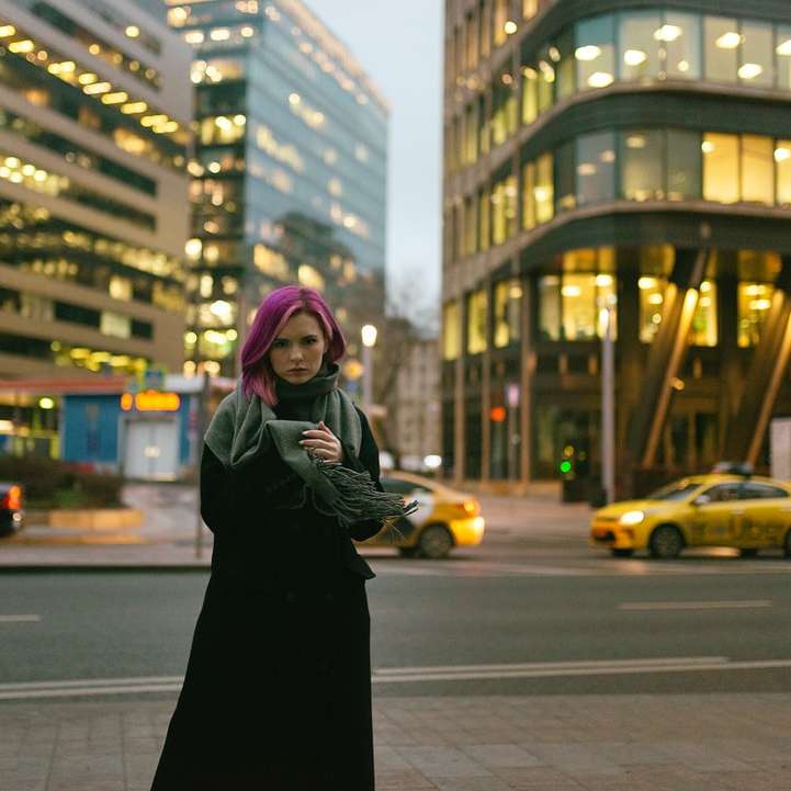 vrouw in zwarte jas staande op de weg overdag online puzzel