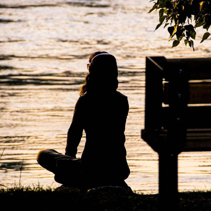 silueta osoby sedící na lavičce poblíž vodní plochy online puzzle