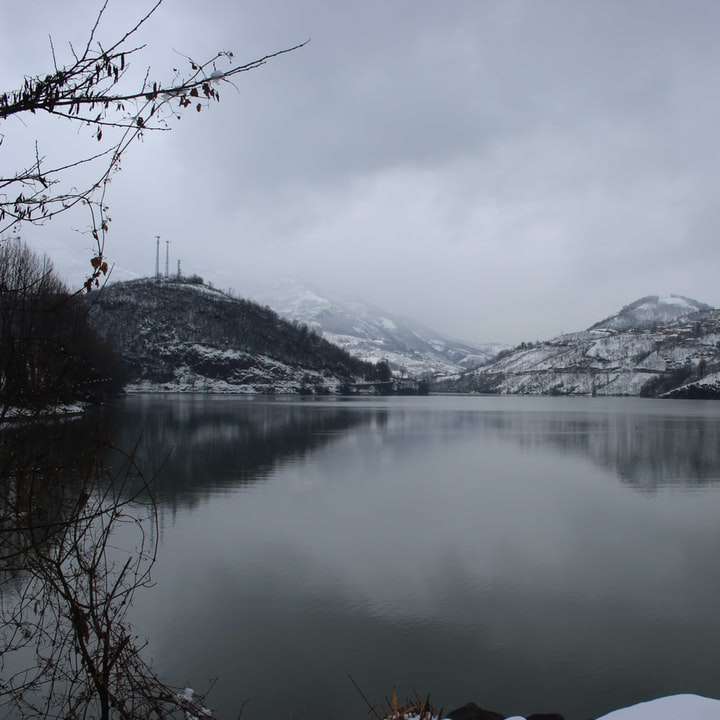 χιονισμένο βουνό κοντά στη λίμνη κατά τη διάρκεια της ημέρας συρόμενο παζλ online