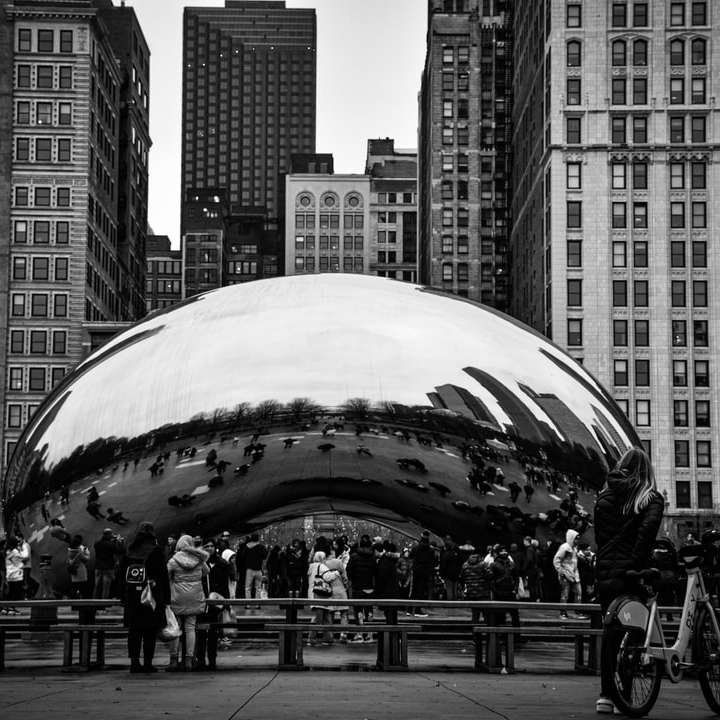 grayscale photo of people walking on street near cloud gate sliding puzzle online