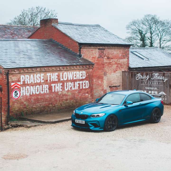 chevrolet camaro azul estacionado ao lado de prédio de tijolos marrons puzzle deslizante online