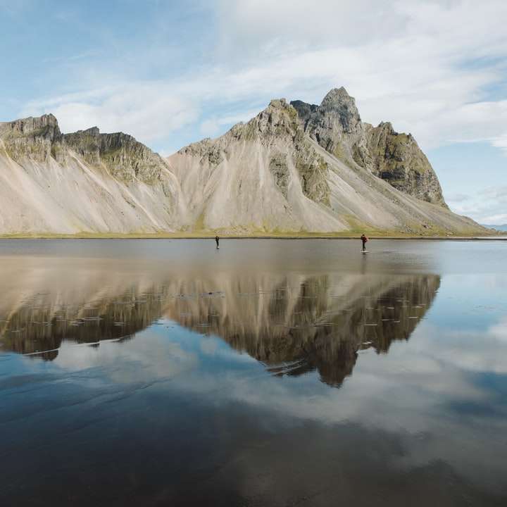 заснежена планина близо до езерото през деня плъзгащ се пъзел онлайн