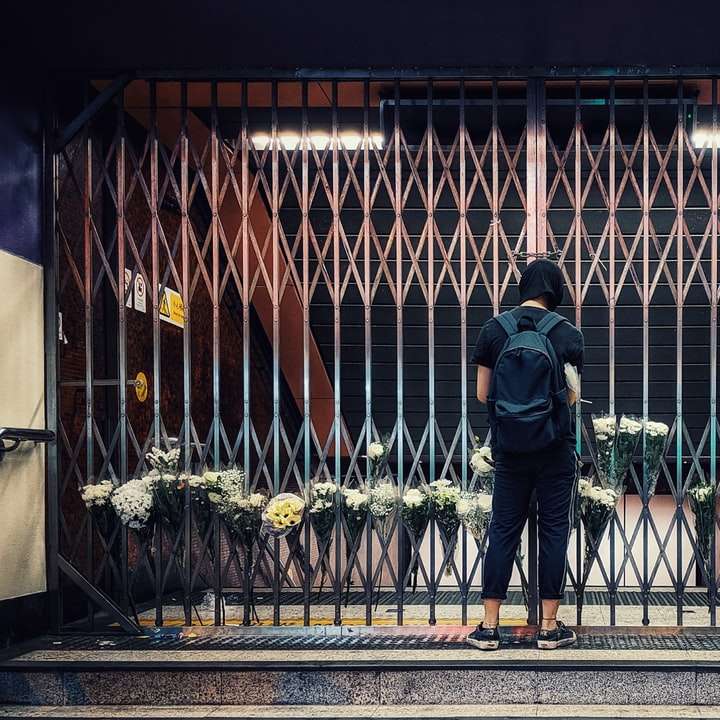 мъж в черно яке и сини дънкови дънки, застанали отпред онлайн пъзел