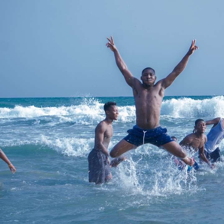 man in blauwe korte broek springen op het water overdag online puzzel
