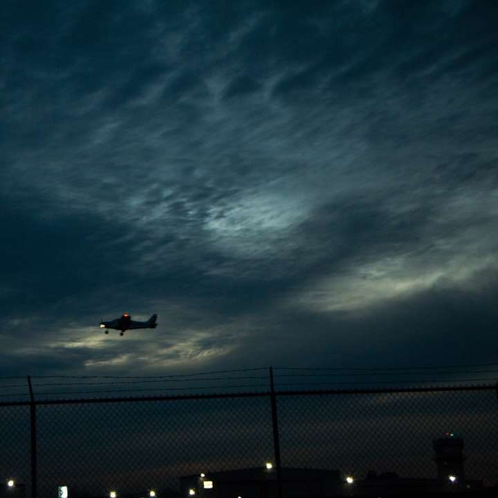 αεροπλάνο που πετά πάνω από την πόλη κατά τη διάρκεια της νύχτας online παζλ