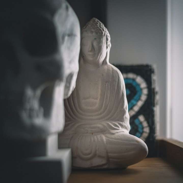 белая керамическая статуэтка будды на коричневом деревянном столе онлайн-пазл