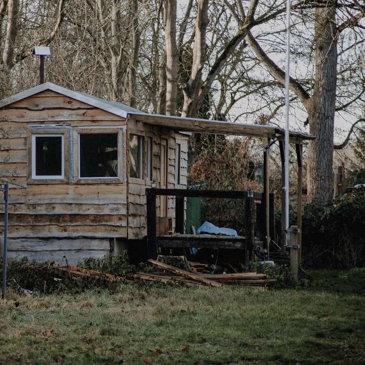 hnědý dřevěný dům poblíž stromů během dne posuvné puzzle online