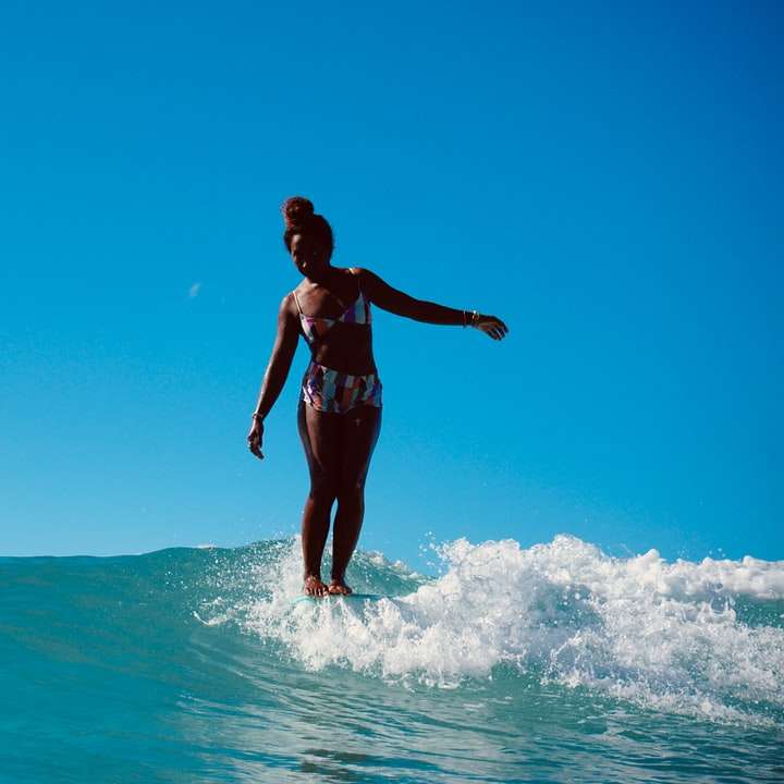 vrouw in zwarte bikini staande op het water overdag online puzzel