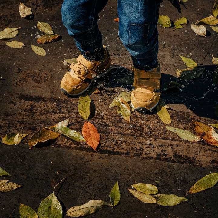 persona in jeans blu denim e scarpe da trekking marroni puzzle scorrevole online