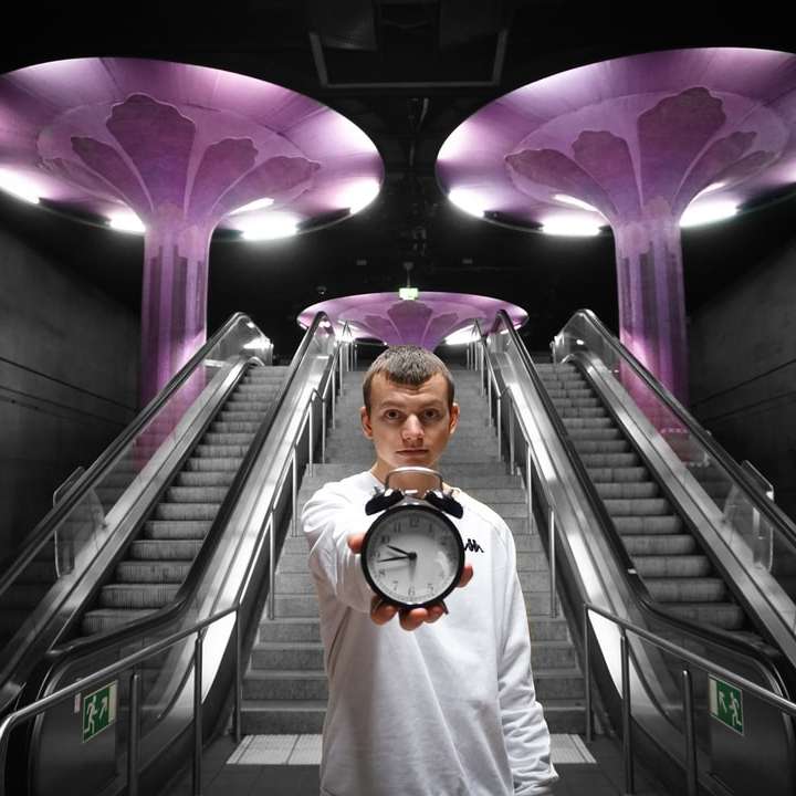 man in white dress shirt standing on escalator sliding puzzle online
