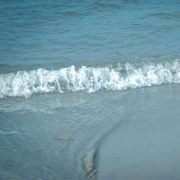 vagues de l'océan s'écraser sur le rivage pendant la journée puzzle coulissant en ligne