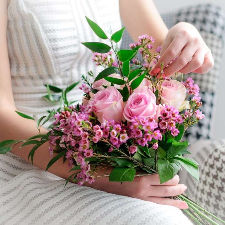 γυναίκα σε λευκό φόρεμα κρατώντας ροζ τριαντάφυλλα συρόμενο παζλ online