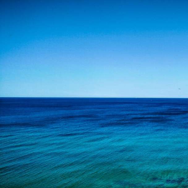 apă albastră a oceanului sub cerul albastru în timpul zilei alunecare puzzle online