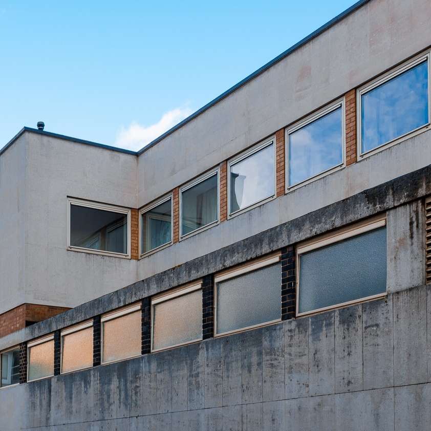 szary betonowy budynek pod błękitnym niebem w ciągu dnia puzzle przesuwne online