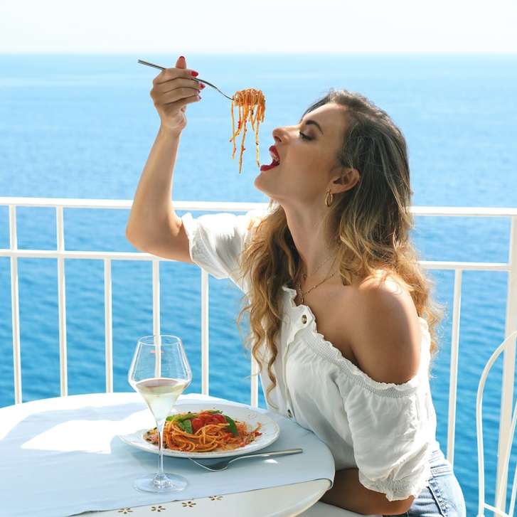 Frau im weißen Spaghettiträgeroberteil, das Gabel und Messer hält Online-Puzzle