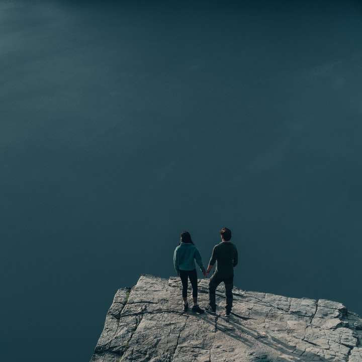 Двама мъже, стоящи на сив бетонен док под синьо небе онлайн пъзел