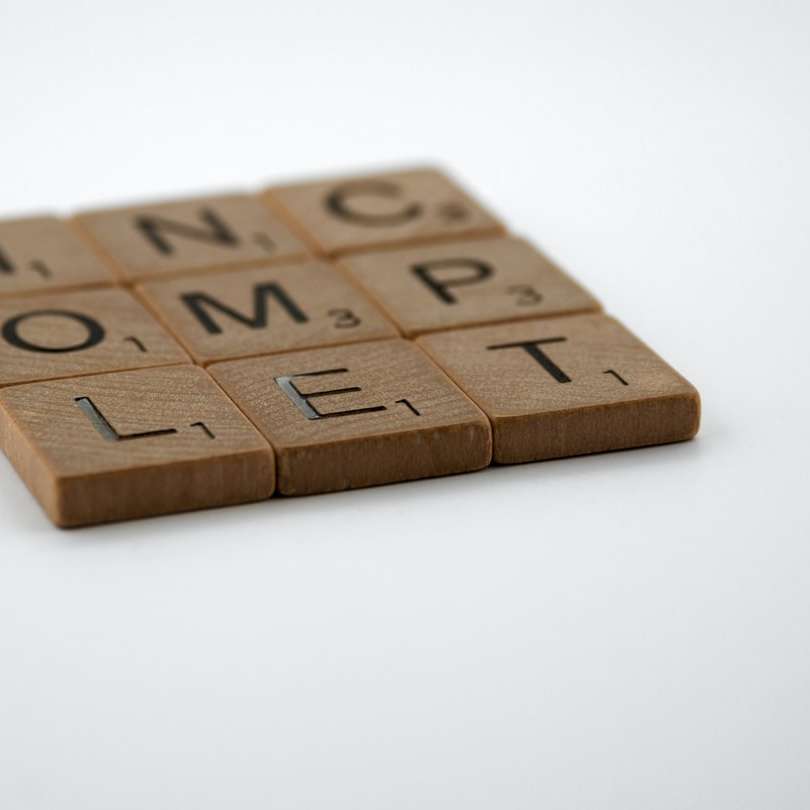 blocos de letras de madeira marrons na mesa branca puzzle deslizante online