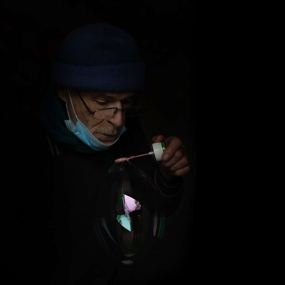 Mann in blauer Strickmütze und schwarzem Hoodie, der Zigarette raucht Online-Puzzle