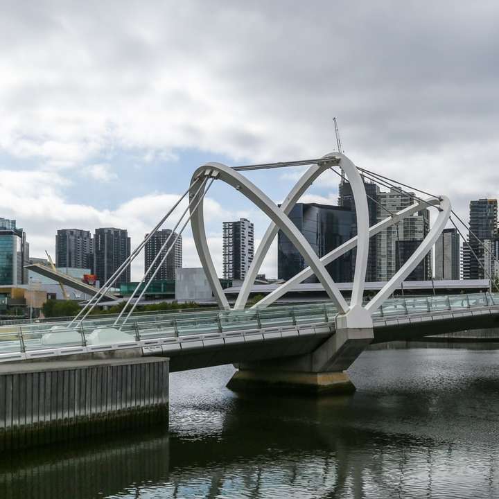λευκή γέφυρα πάνω από τον ποταμό κάτω από συννεφιασμένο ουρανό κατά τη διάρκεια της ημέρας συρόμενο παζλ online