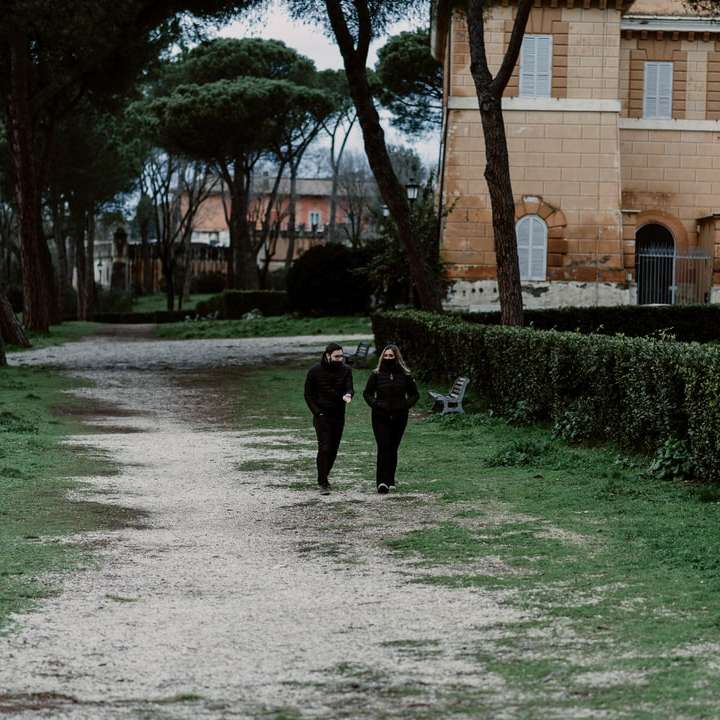 pessoa de jaqueta preta caminhando em um caminho de concreto cinza puzzle online