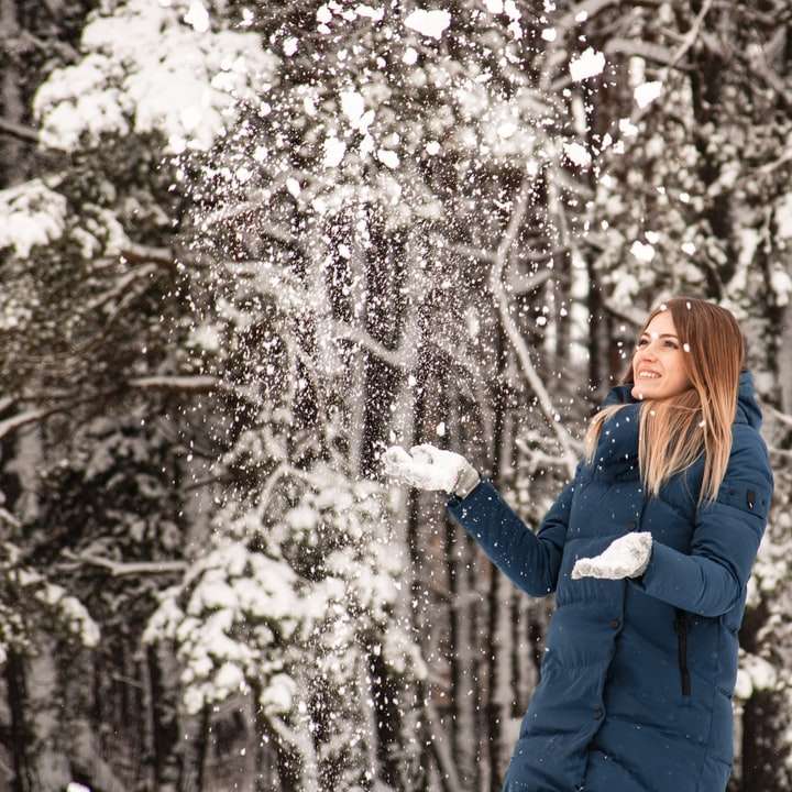 mulher de casaco azul debaixo de uma árvore branca puzzle online